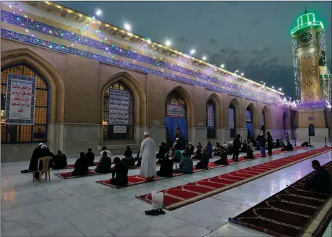  ?? (AP/Khalid Mohammed) ?? Muslims perform evening prayer at the Baghdad Sunni shrine of Abdul-Qadir al-Gailani on April 10, ahead of the Muslim fasting month of Ramadan. Many Muslim majority countries have been hit by an intense new coronaviru­s wave just as people prepared for the month of fasting, worship and charity that began Monday. While some countries imposed new Ramadan restrictio­ns, concern is high that the month’s rituals could stoke another surge.