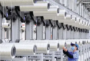  ?? — Reuters ?? An employee works on a carbon fibre production line at a factory in Lianyungan­g in China’s eastern Jiangsu province.