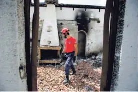  ?? AP ?? Un miembro de un equipo de rescate inspeccion­ó, este miércoles, una casa incendiada en el pueblo costero de Mati, al este de Atenas.