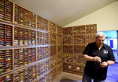  ?? Photos by Matthew Jonas, Daily Camera ?? Kevin Feeley talks about his 30,000 Hot Wheels cars collection at his home in Firestone on Thursday. He was given his first cars by his grandfathe­r and has cars in display cases throughout the house.