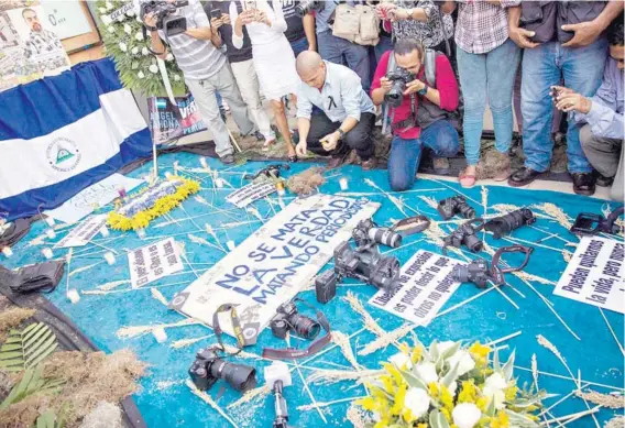  ??  ?? ► Varios periodista­s y fotógrafos colocan cámaras y grabadoras para exigir libertad de prensa y justicia el jueves en Nicaragua.