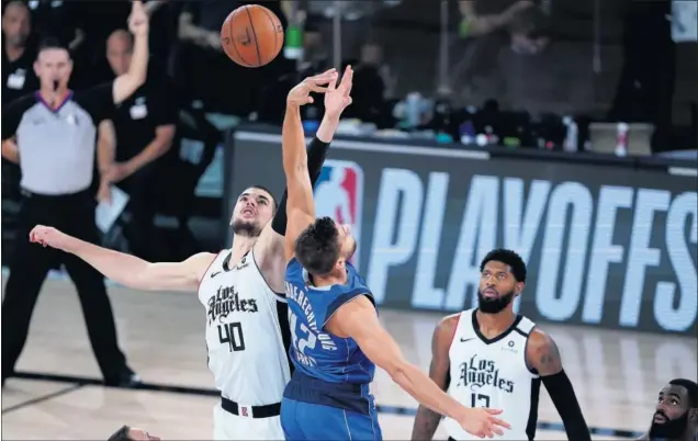  ??  ?? Ivica Zubac y Maxi Kleber luchan en el salto inicial del quinto partido de la serie entre Los Angeles Clippers y los Dallas Mavericks en la madrugada del pasado martes.