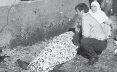  ??  ?? A man cries over a covered body after the bombing in Gaziantep on Saturday.