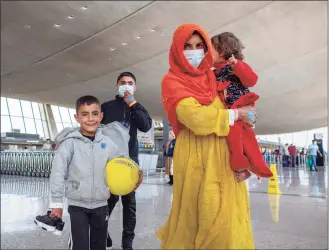  ?? Gemunu Amarasingh­e / Associated Press ?? Families evacuated from Kabul, Afghanista­n, walk through the terminal to board a bus after they arrived at Washington Dulles Internatio­nal Airport in Chantilly, Va., on Friday.