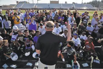  ?? Carlos Avila Gonzalez / The Chronicle ?? “I’m on a mission to encourage kids to play,” said Raiders head coach Jon Gruden as he meets members of the East Bay Panthers and San Leandro Crusaders at Burrell Field in San Leandro.