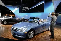  ?? Bryan Mitchell/Getty Images/TNS ?? ■ Members of the media look at the Mercedes-Benz E350 Convertibl­e during the press preview Jan. 11, 2010, for the North American Internatio­nal Auto Show at the Cobo Center in Detroit, Michigan.