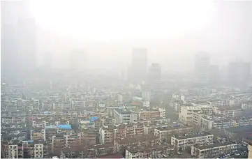  ??  ?? Residentia­l buildings are seen in smog during a polluted day in Nanjing, Jiangsu province, China. — Reuters photo