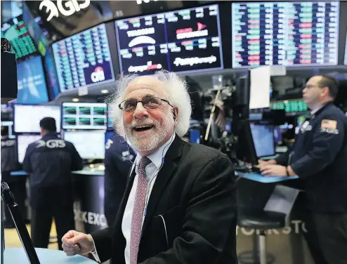  ?? SPENCER PLATT / GETTY IMAGES ?? Traders on the floor of the New York Stock Exchange had reason to smile on Friday when the Dow soared by some 400 points. The ups and downs of the markets will teach investors of all ages about risk.