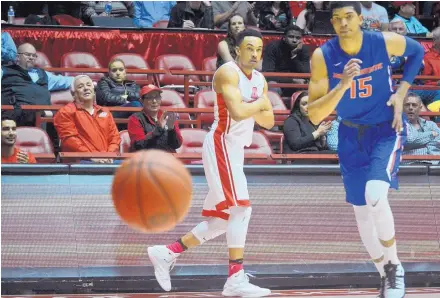  ?? MARLA BROSE/JOURNAL ?? New Mexico’s Elijah Brown (4) strikes a pose after hitting a 3-point shot as Boise State’s Chandler Hutchison, right, chases the basketball during Tuesday night’s game in the Pit. Brown scored 27 points as UNM won 78-73.