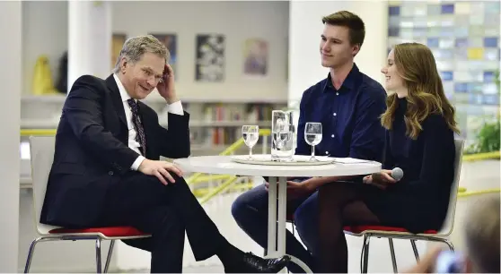  ?? FOTO: JONAS EDSVIK ?? President Sauli Niinistö hade tid för en diskussion med Pontus Påvals, Ålands yrkesgymna­sium, och Elin Boman, Ålands lyceum, då han besökte stadsbibli­oteket