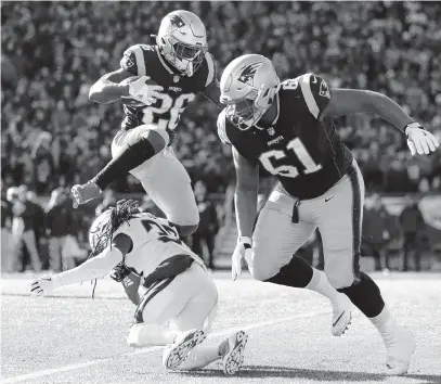  ?? MADDIE MEYER/GETTY IMAGES ?? Sony Michel of the New England Patriots leaps over Jahleel Addae of the Los Angeles Chargers during the first quarter in the AFC Divisional Playoff Game at Gillette Stadium Sunday. Michel scored three touchdowns in the Patriots’ 41-28 win over the Chargers.