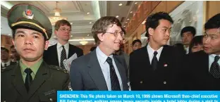  ??  ?? SHENZHEN: This file photo taken on March 10, 1999 shows Microsoft then-chief executive Bill Gates (center) walking among heavy security inside a hotel lobby during a visit to Shenzhen. — AFP