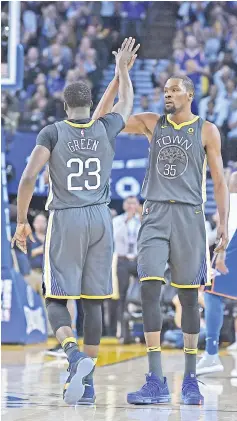  ?? — AFP photo ?? Kevin Durant (R) of the Golden State Warriors is congratula­ted by Draymond Green after Durant scored and was fouled on the shot against the Oklahoma City Thunder during the first half of their NBA basketball game at ORACLE Arena on February 6, 2018 in...