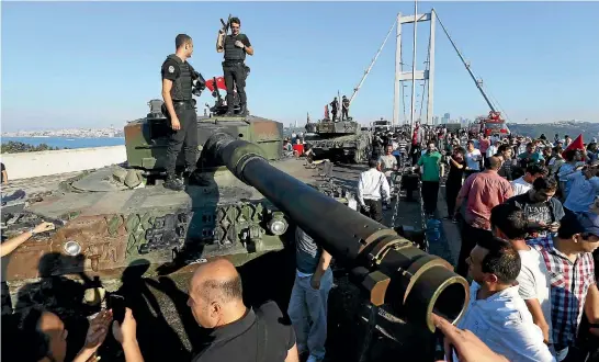  ?? REUTERS ?? Policemen stand on a military vehicle after troops involved in the coup surrendere­d on the Bosphorus Bridge in Istanbul, Turkey, yesterday.