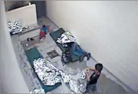  ?? AP ?? Migrants, including children, with Mylar sheets on concrete floor of a Border Patrol detention facility in Douglas, Ariz.