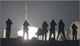  ?? AP ?? Journalist­s photograph the Soyuz rocket booster and Soyuz spaceship carrying a new crew to the Internatio­nal Space Station. The ship blasted off from Kazakhstan on Saturday. The craft carries U.S. astronaut Scott Kelly and two Russian cosmonauts.