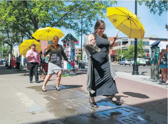  ?? GAVIN YOUNG ?? In 2017, Bruce Furlong, from left, and Chris Thompson-Hunter with the City of Calgary and Annie MacInnis with the Kensington BIA tried out some rain art hopscotch in Kensington. With new condos attracting new residents, Kensington is booming, and the BIA and community associatio­n are working together to make the enclave a vibrant, bustling place to live.