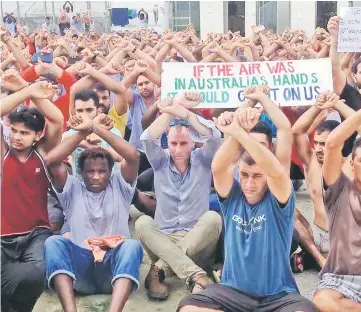  ??  ?? This handout picture shows refugees gesturing inside the Manus detention camp in Papua New Guinea on the day of the camp’s expected closure. — AFP photo