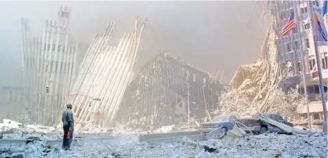  ?? FILE PHOTO BY DOUG KANTER, AFP/ GETTY IMAGES ?? A man stands amid the rubble, calling out to see if anyone needs help, after the collapse of the first World Trade Center tower in New York on Sept. 11, 2001.