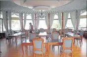  ??  ?? A worker sets the chairs at an empty state tourism department restaurant in Shimla on Sunday.