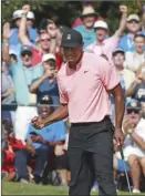  ?? The Associated Press ?? Tiger Woods and the gallery react as he sinks an eagle putt on the 18th hole during the first round of the Tour Championsh­ip on Thursday in Atlanta.