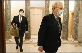  ?? JACQUELYN MARTIN — THE ASSOCIATED PRESS ?? Followed by a staffer holding a bag, Senate Majority Leader Mitch McConnell of Ky., right, leaves the Capitol for the day, Tuesday, on Capitol Hill in Washington.