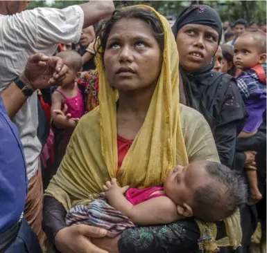  ?? DAR YASIN/THE ASSOCIATED PRESS ?? Rohingya Muslim women, who crossed over from Burma into Bangladesh, wait to receive aid near Balukhali refugee camp.