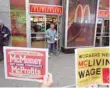  ?? — Reuters ?? A man exits at McDonald’s restaurant as protesters shout slogans in Times Square, New York.