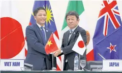  ??  ?? TRADING UP: Japan Trade Minister Toshimitsu Motegi with Vietnamese counterpar­t Tran Tuan Anh after attending a news conference on the TPP in Danang, Vietnam, yesterday.