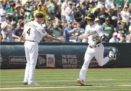  ?? Jeff Chiu / Associated Press ?? Oakland’s Mark Canha is congratula­ted by third-base coach Matt Williams after hitting a solo home run in the fifth inning.