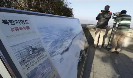  ?? LEE JIN-MAN, THE ASSOCIATED PRESS ?? A visitor uses binoculars to see the north side from the unificatio­n observator­y in Paju, South Korea, Tuesday. Four North Korean soldiers fired 40 rounds at a comrade fleeing south and hit him five times.