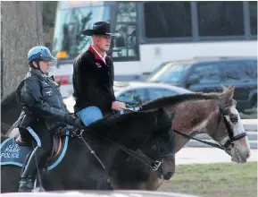  ?? INTERIOR DEPARTMENT ?? Interior Secretary Ryan Zinke, decked out with hat and horse, arrives for his first day of work, escorted by the U.S. Park Police.