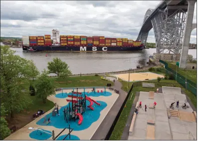  ?? (AP/Ted Shaffrey) ?? A container ship en route to the Port of New York and New Jersey passes a playground and a skateboard park in Bayonne, N.J., last month.