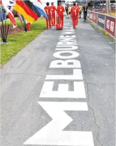  ?? FOTO: WILLIAM WEST/AFP ?? Mitglieder des Ferrari-Teams verlassen den Albert Park. Der Australien-GrandPrix wurde in der Nacht zu Freitag abgesagt.