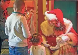  ?? MONICA D. SPENCER/THE REPUBLIC ?? Andrea Ascencio, Emilia Frierson, Robby Frierson and Danny Frierson gather to greet Santa Claus before taking a photo inside Santa’s Cottage at the Outlets at Anthem in Phoenix on Dec. 19, 2021.