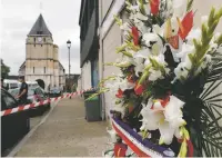  ?? FRANÇOIS MORI/THE ASSOCIATED PRESS ?? A wreath of flowers from the Muslims of France Associatio­n is placed outside the church Wednesday where a terrorist attack left a priest dead Tuesday in Saint-Etienne-du-Rouvray, France.