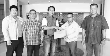  ??  ?? Dennis (centre) receives a contributi­on from Suffian Sabeli of SSGP witnessed by (from left) SSGP executive Walter Anyie Tomy, political secretary to the Chief Minister Charles Balan Seling and Tang Sing Chuong of Pekerjaan Piasau Konkerit Sdn Bhd.