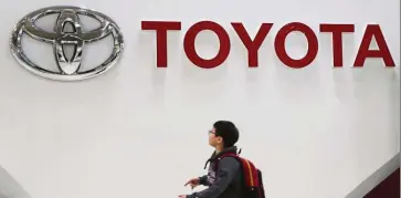  ?? — AP ?? Sales down: The logo of Toyota Motor Corp is seen at its gallery in Tokyo. The company expects an 80% drop in full-year operating profit.