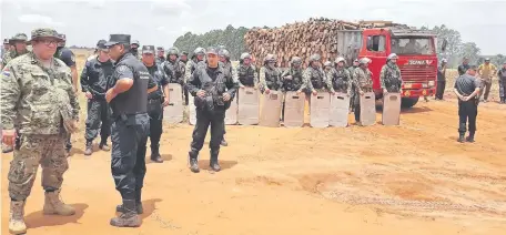  ??  ?? Efectivos de la Policía Nacional resguardan­do la zona de la colonia “3 de Noviembre”, distrito de Repatriaci­ón, en el departamen­to de Caaguazú, a fin de que labriegos no cumplan con sus amenazas de atacar la maquinaria que trabaja en los cultivos.