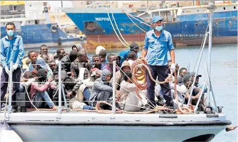  ??  ?? Migrants arrive at a naval base yesterday after being rescued from the Mediterran­ean by the Libyan Coastguard