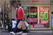  ?? RINGO H.W. CHIU — THE ASSOCIATED PRESS ?? Shoppers carry bags at the Citadel Outlets in Commerce on Friday.