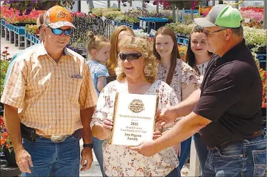  ?? Westside Eagle Observer/RANDY MOLL ?? Jim and Michele Pigeon (left) receive the Benton County Farm Family of the Year plaque from Charlie Coffelt, representi­ng the Benton County Farm Family of the Year selection team, on Friday.