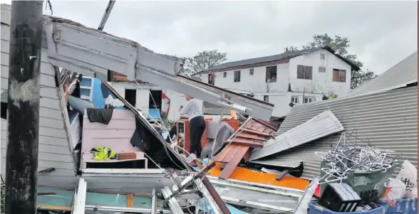  ?? Photo: Vanessa Haleta ?? A woman looks through the ruins after Cyclone Gita devastated the Kingdom of Tonga on January 13, 2018.