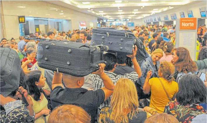  ?? M. QUINTEROS ?? Colapso. A medida que pasaban las horas llegaban más pasajeros a Aeroparque. Una empleada les pedía que reprograme­n sus vuelos en la página web o en la aplicación.