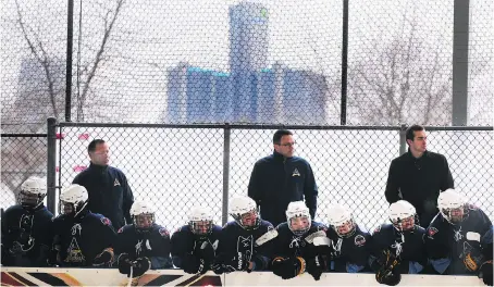  ?? PHOTOS: DAN JANISSE ?? With Detroit highrises shown in the background, the Amherstbur­g bench is shown during the Junior C Outdoor Shinny Series game between the Amherstbur­g Admirals and Wallacebur­g Lakers on Saturday at Lanspeary Park.