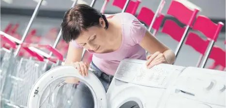  ??  ?? Junge Frau beim Begutachte­n einer Waschmasch­ine, neues Energielab­el: „Die Europäisch­e Union will mit der neuen Kennzeichn­ung Hersteller­n Druck machen, noch effiziente­re Geräte zu bauen“, sagt Daniel Kastner von der Stiftung Warentest, die die Novelle überprüft hat.