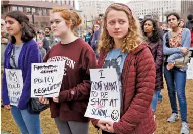  ?? STAFF PHOTOS BY DOUG STRICKLAND/ ?? From left, Rosa Anderson, Virginia Alsoerooks and Ellie Swann react Saturday as the names of 17 victims of last year’s school shooting in Parkland, Fla., are read during a rally against gun violence organized by Chattanoog­a Students Leading Change in Miller Park.