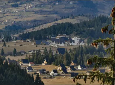  ?? (AP/Almir Alic) ?? The afternoon sun illuminate­s hotels and houses in Vlasic, a ski resort affected by unusually warm weather in Bosnia last week.