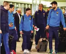  ?? AFP ?? Star cast Barcelona team members Luis Suarez (second from left), Lionel Messi (centre) and Gerard Piquet (right) chat upon their arrival at the Narita internatio­nal airport yesterday.