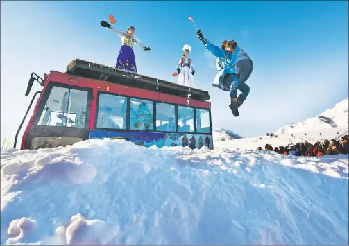  ?? PHOTOS BY ZHAO GE / XINHUA ?? Hemu villagers jump into snowdrifts to entertain tourists during the snow festival.